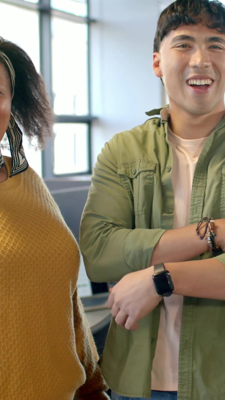 Video verticale: Uomo che ride che sistema i braccialetti, appoggiando il braccio su una donna in ufficio a dimostrazione di supporto