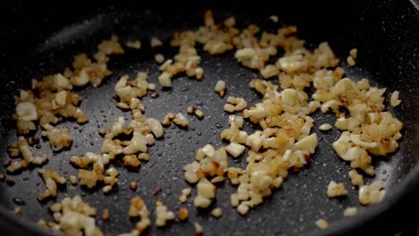 person cooking pasta on frying pan