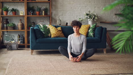 woman meditating in a home living room
