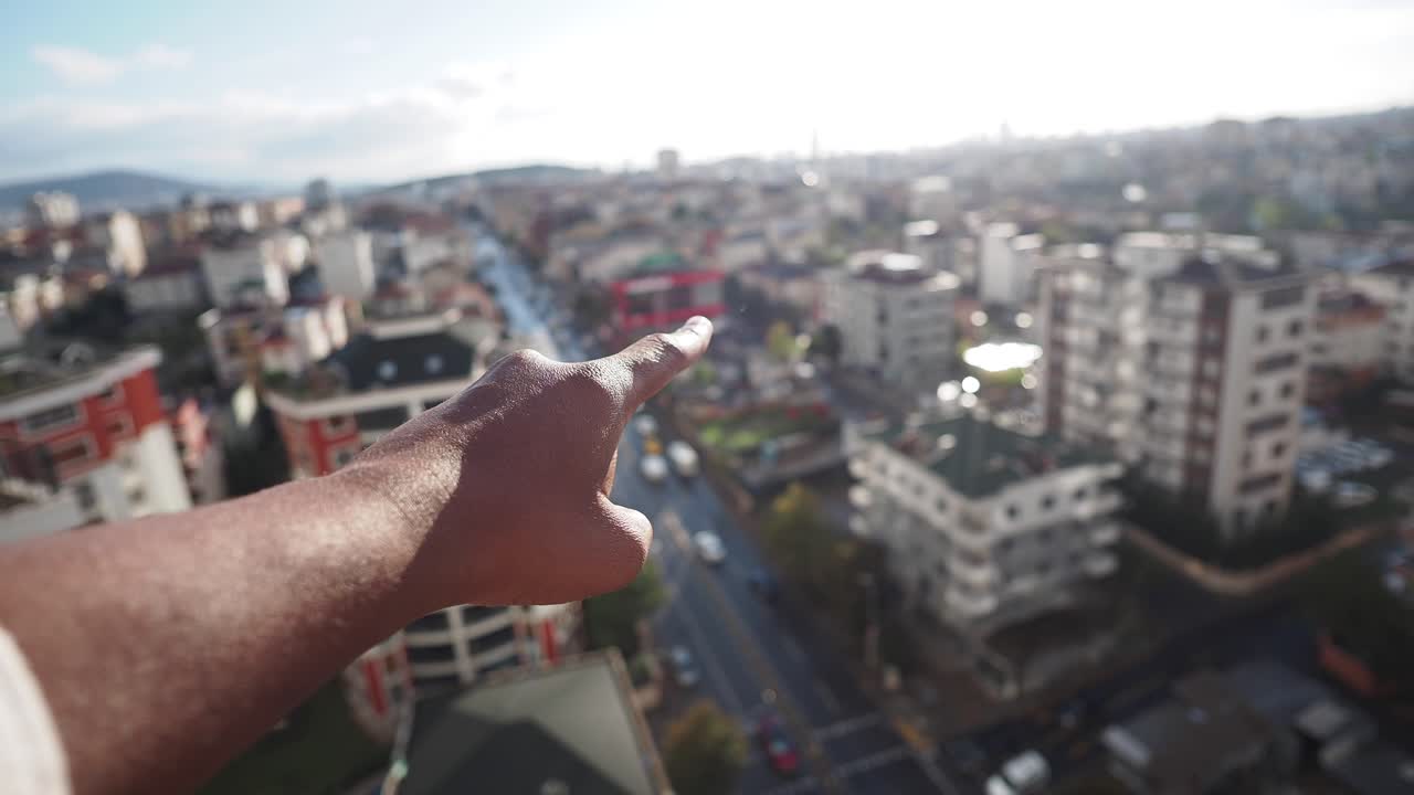 Cityscape view with pointing finger