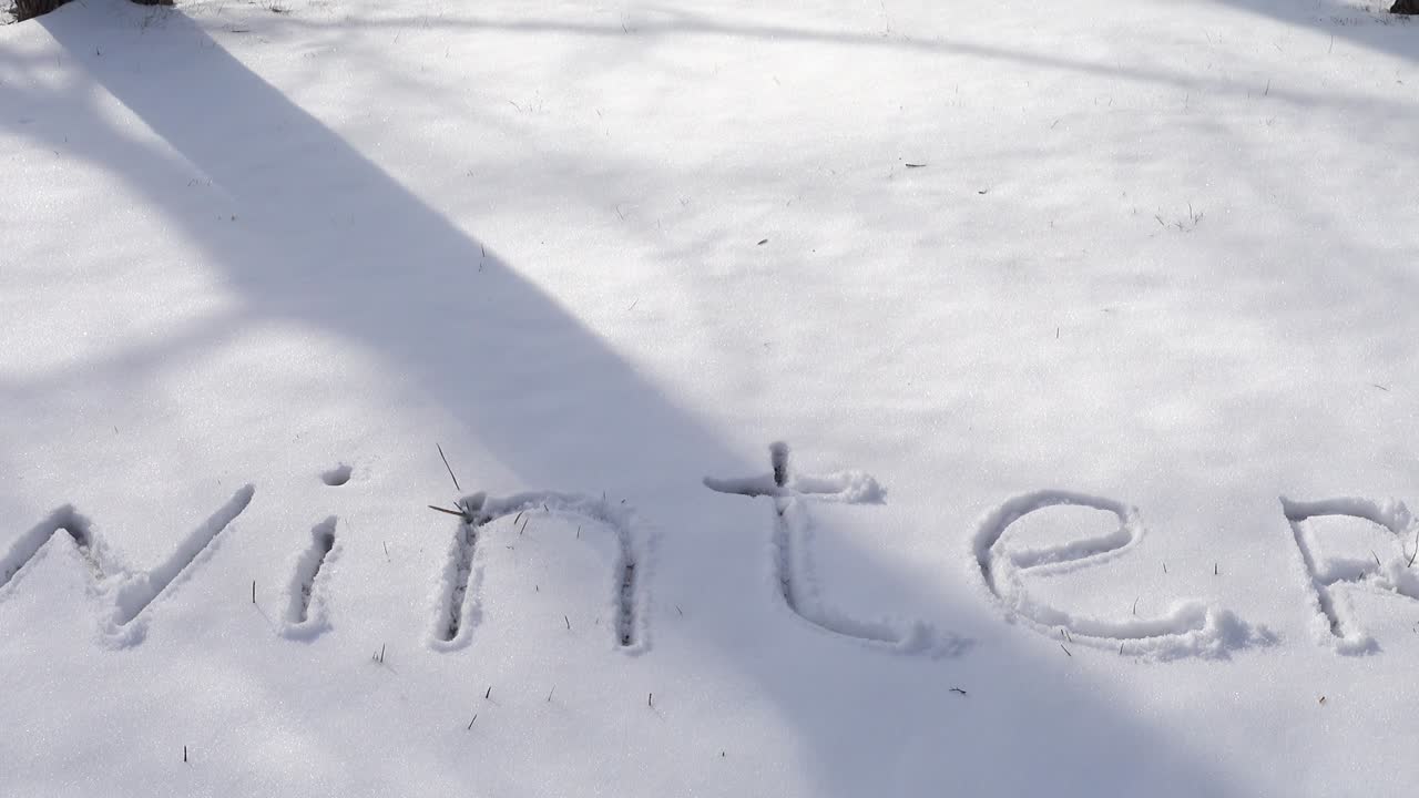Inscriptie 'winter' in de sneeuw. Opname in de winter