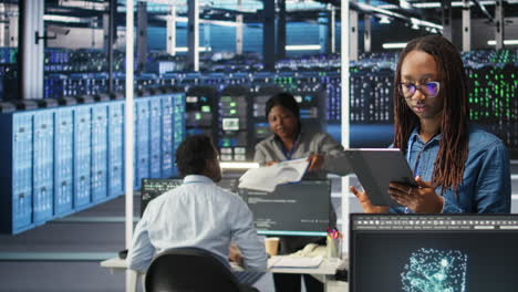 portrait of smiling server room engineer using device to interpret ai data