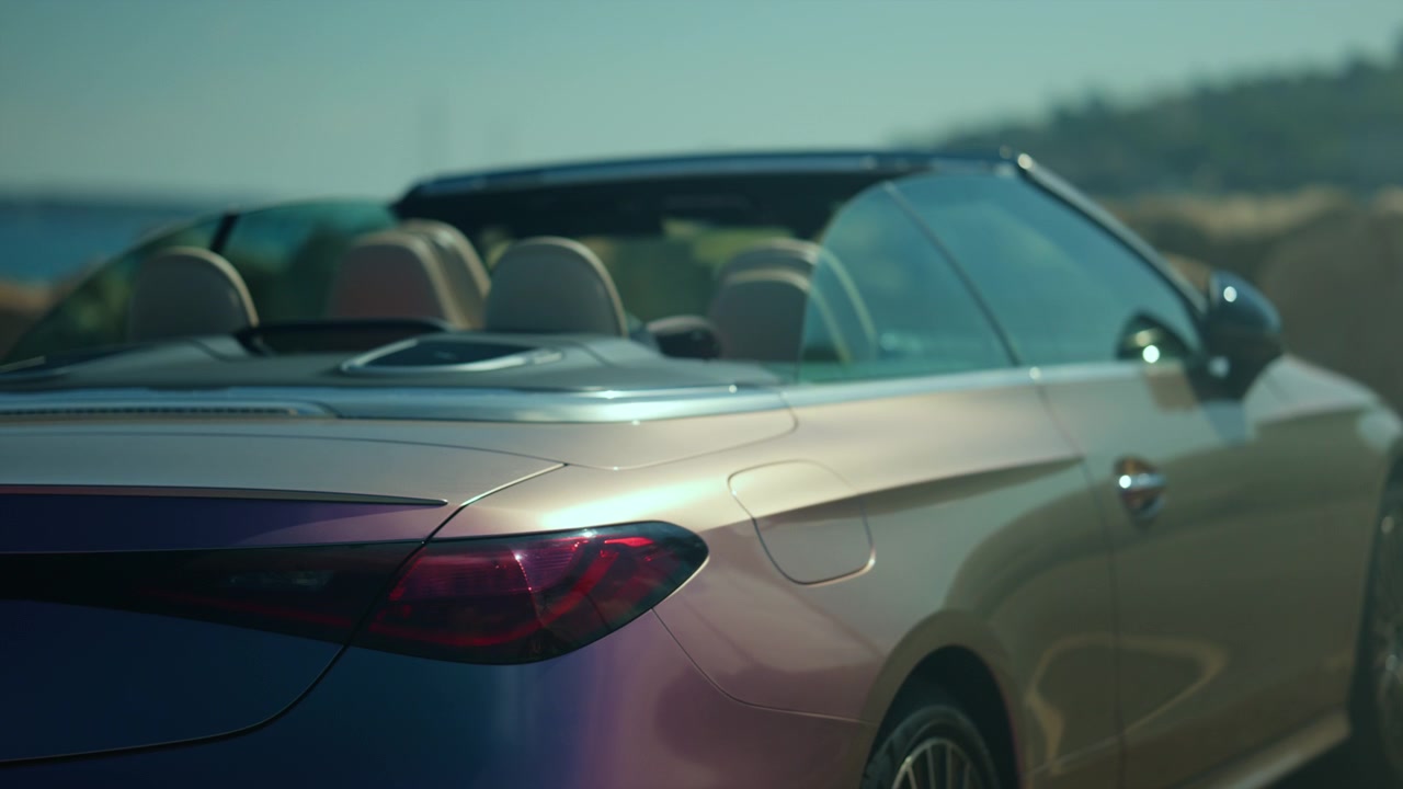 Dettaglio ravvicinato degli interni e del parabrezza di una cabriolet di lusso, che evidenzia design moderno e lavorazione artigianale di pregio