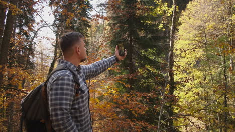 hombre tomando una selfie en el bosque de otoño