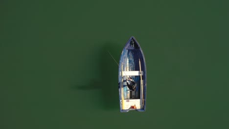 woman on the boat catches a fish on spinning in norway.