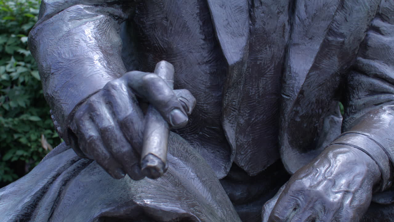 Close-up of a Bronze Statue of a Man in a Suit and Glasses