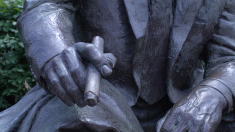close-up of a bronze statue of a man in a suit and glasses