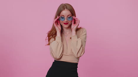 Sincera-Y-Alegre-Chica-Morena-Con-Blusa-Beige-Con-Gafas-De-Sol,-Sonrisa-Encantadora-En-La-Pared-Rosa