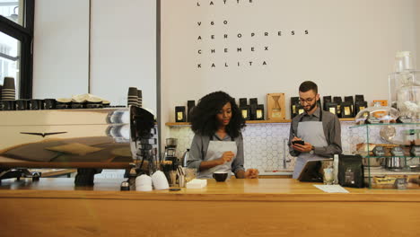 barista masculino caucásico y compañera de trabajo caucásica trabajando en una cafetería moderna