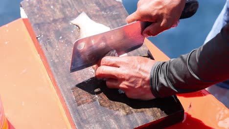person filleting fish on a wooden board