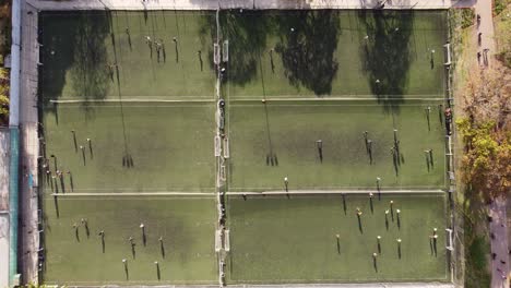 six soccer football training fields ina a row and players practicing