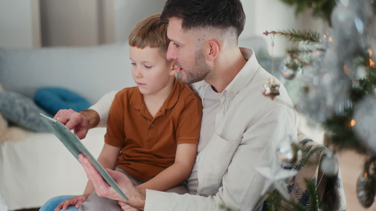 un niño y su padre miran fotos en un álbum