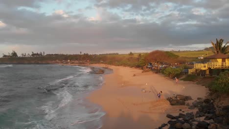 waves roll in to ho'okipa beach, maui, hawaii at sunset as seen from a drone.