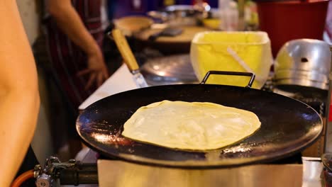 vendor prepares roti with egg and banana