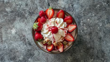 close-up of a delicious dessert with ice cream, strawberries, whipped cream and cherry