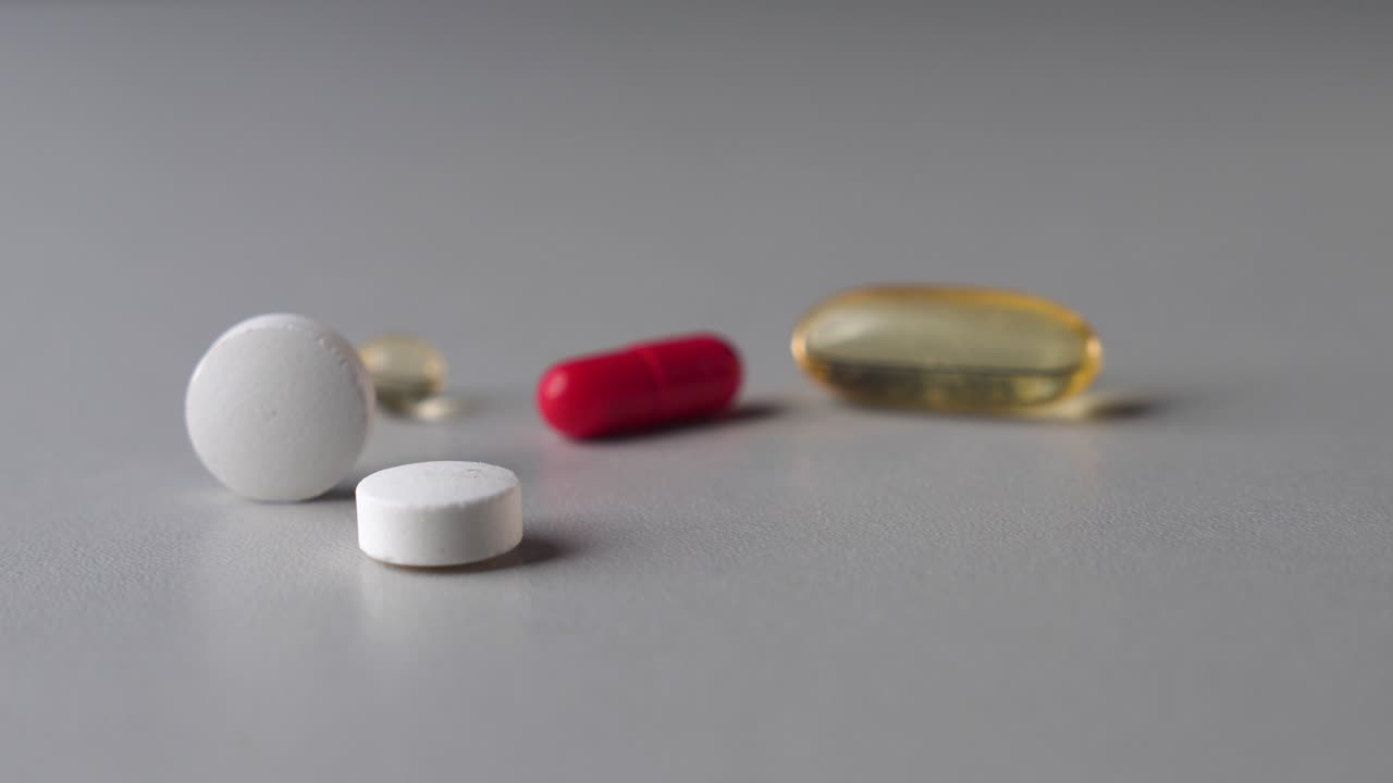 suplementos dietéticos de diferentes colores y formas, rollo de comprimidos redondos y parada