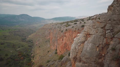 Time-lapse-of-sun-rays-moving-across-valley-below-steep-cliffs,-Nahal-Amud,-Israel