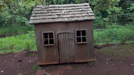 a rustic wooden hut in a lush green forest