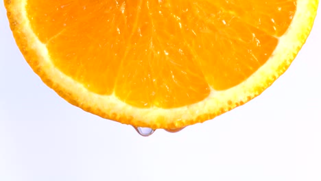 water or oils dropping on an orange slice , fruit for diet and healthy food