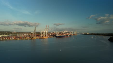 ascending flight over test river overlooking container terminal in the distance in southampton, england, uk