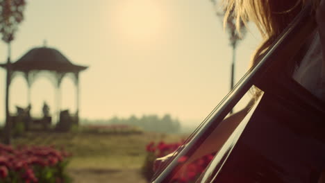 raggi di sole luminosi attraverso il profilo di una donna che suona musica in un parco in fiore all'aperto.