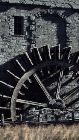 closeup of an old water wheel on a stone building