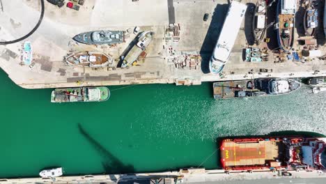 aerial drone shot flying sideways with a top down view of ships in a boat yard