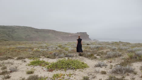 mujer caminando por un camino costero