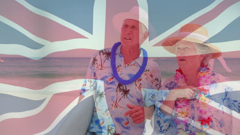 animación de la bandera de la unión sobre una pareja de ancianos en trajes tropicales en la playa