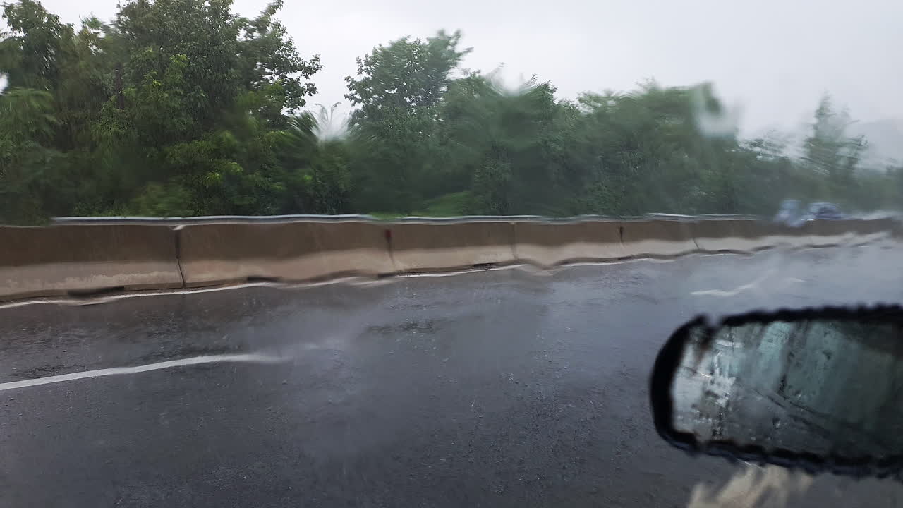 View of traffic out of parked car window during heavy rainstorm