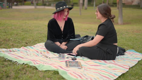 two women relaxing and creating art in the park