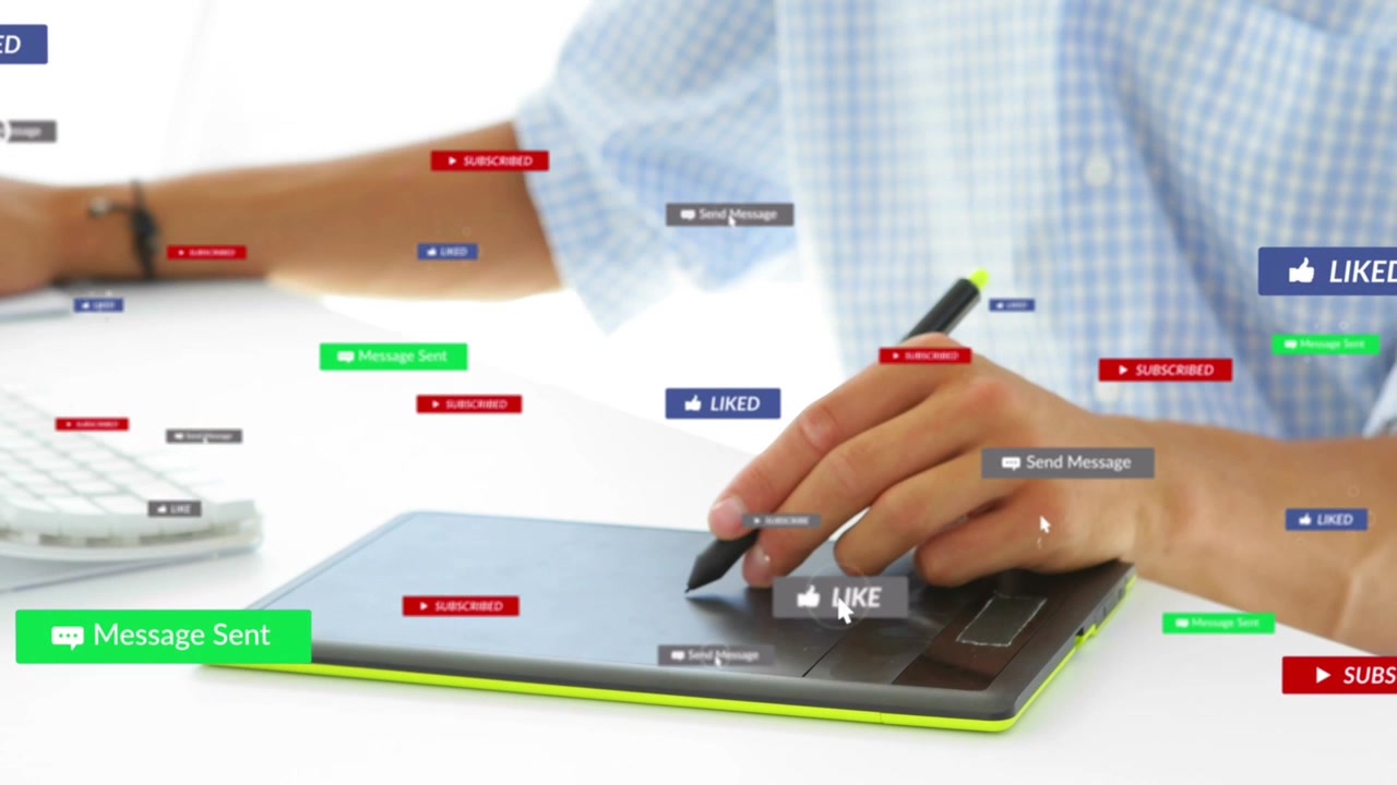 Designer tapping tablet and typing keyboard generating social badges crowding hands engaging users