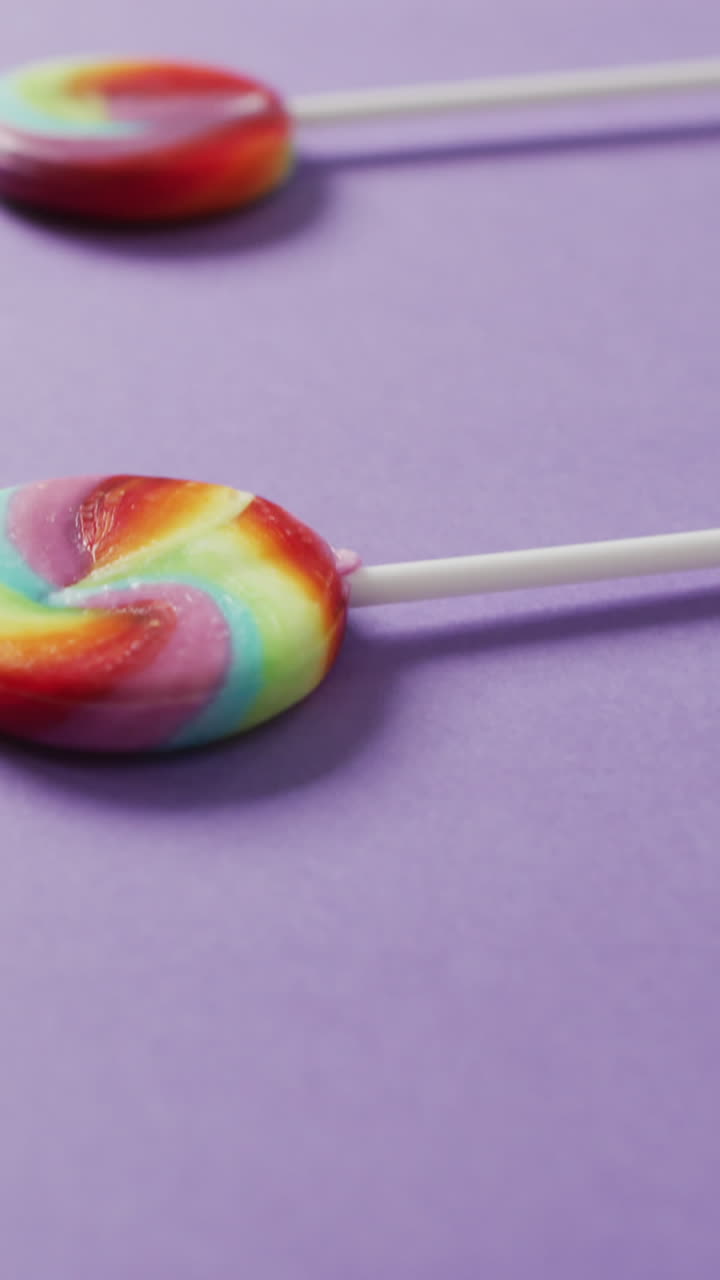 vídeo de filas de piruletas multicolores sobre un fondo azul