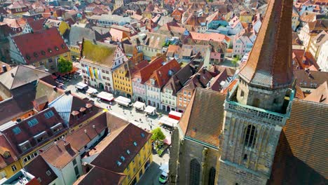 4k aerial drone video of farmers market in the courtyard between the st. johannis kirche church and kirche st. gumbertus church in ansbach, germany