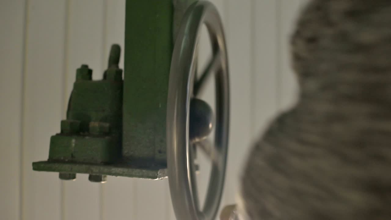 손의 클로즈업: 남성 연구원이 태양 관측소의  잎의 개방 메커니즘의 수동 바를 회전시니다.