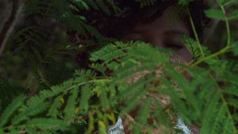 facial close up of a brown eye girl with leaves in the foreground