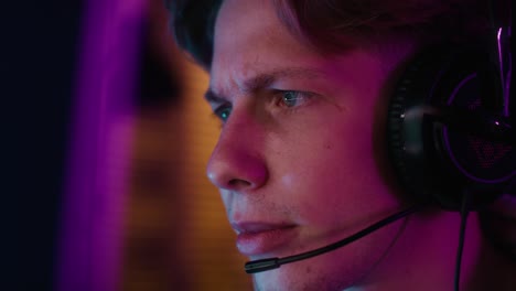 close up of caucasian man playing game at night among neon lightnin