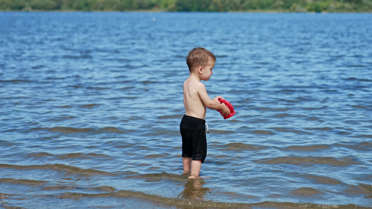 Niño pequeño jugando en el lago