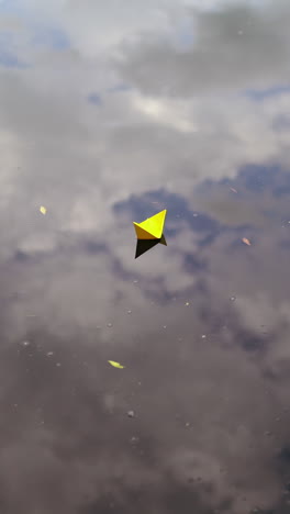 A paper boat sails along the river. Vertical video