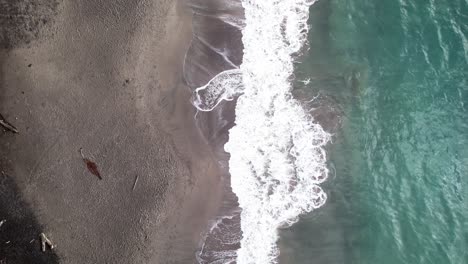 Draufsicht-Auf-Die-Wellen,-Die-Am-Sandstrand-Von-Grand-Anse,-Guadeloupe,-Frankreich,-Plätschern---Drohnenaufnahme