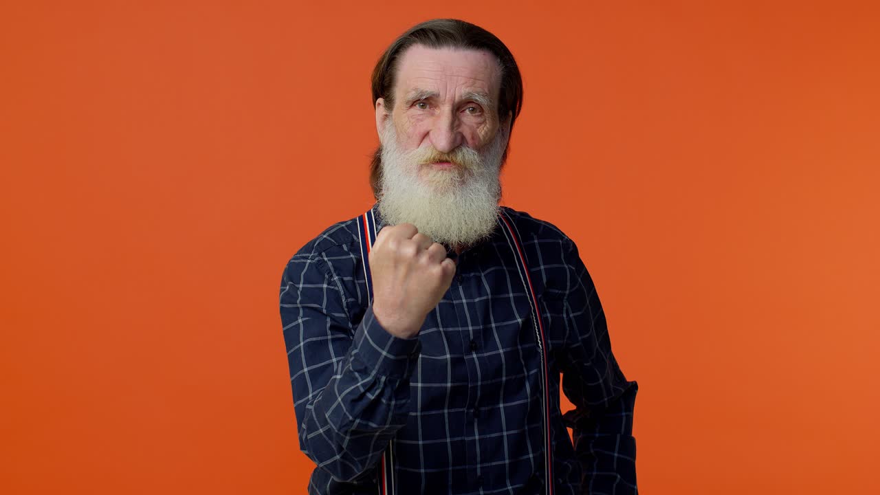 Aggressive angry senior bearded man trying to fight at camera, shaking fist, boxing, punishment
