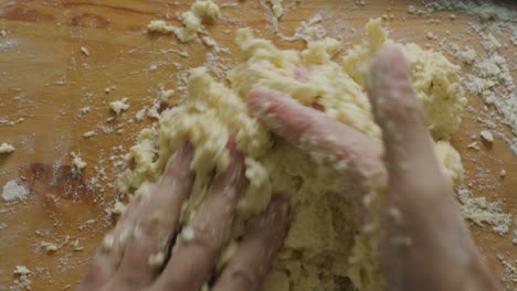 Hands Kneading Dough Mixture on Wooden Kitchen Table
