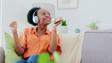 Woman-dancing-on-couch-with-headphones