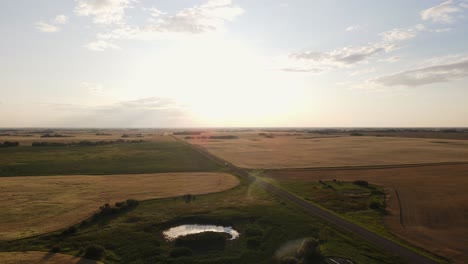 Drone-flying-high-above-remote-farmland-during-sunset