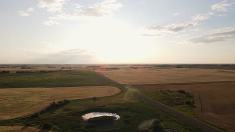 drone volando alto sobre tierras de cultivo remotas durante la puesta de sol
