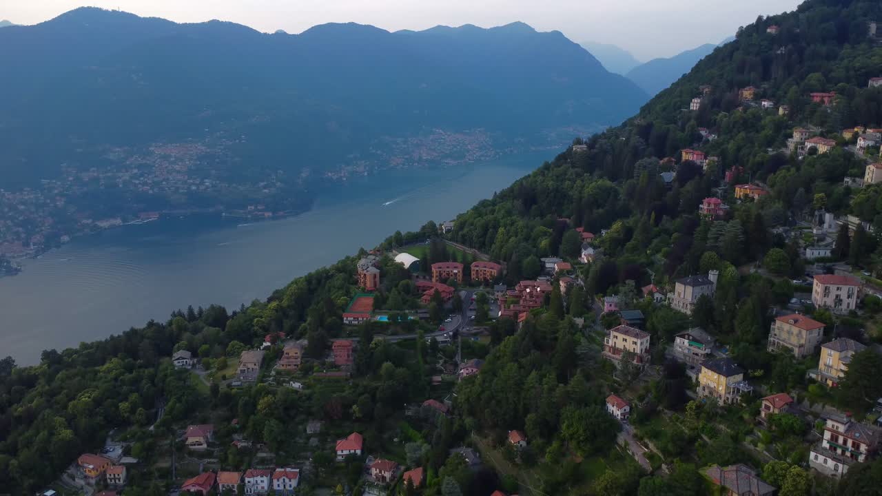 video aéreo de drones de casas en una colina con el lago como y las montañas en el fondo