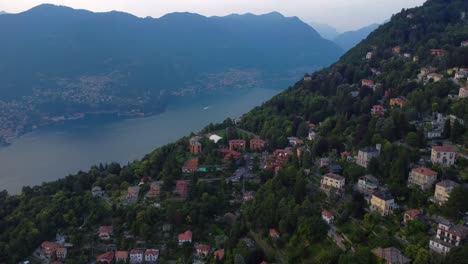 Luftdrohnenvideo-Von-Häusern-Auf-Einem-Hügel-Mit-Comer-See-Und-Bergen-Im-Hintergrund