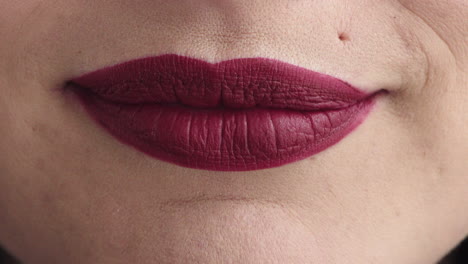 cerrar los labios de la mujer sonriendo feliz usando lápiz labial rojo maquillaje cosméticos belleza femenina dientes sanos
