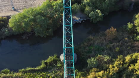 Viejo-Puente-De-Tren-Turquesa-Sobre-Un-Río-En-El-Campo-De-Madrid,-órbita-Aérea