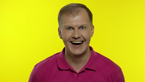 portrait of young caucasian man posing in pink t-shirt. amazed handsome guy shocked, surprised